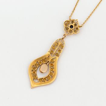 A necklace set with seed pearls, a cabochon cut sapphire, probably another sapphire and filigree work.