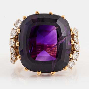 1097. An 18K gold ring set with a faceted amethyst and round brilliant-cut diamonds.