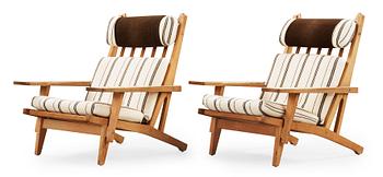 A pair of Hans J Wegner oak and fabric easy chairs, Getama, Gedsted, Denmark 1950's-60's.