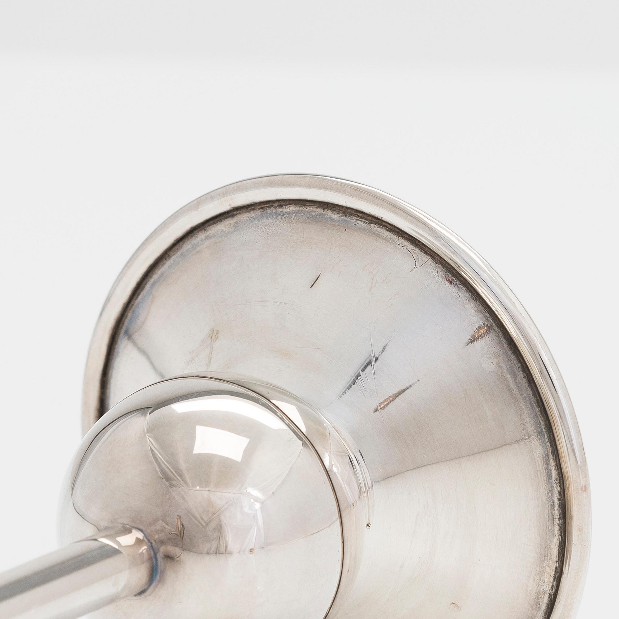 Ljusstake, silver, Kaj Blomqvist, Kultakeskus Tavastehus 1967 och kanna, silver, teak, Hopeatehdas Oy, Helsingfors 1962.