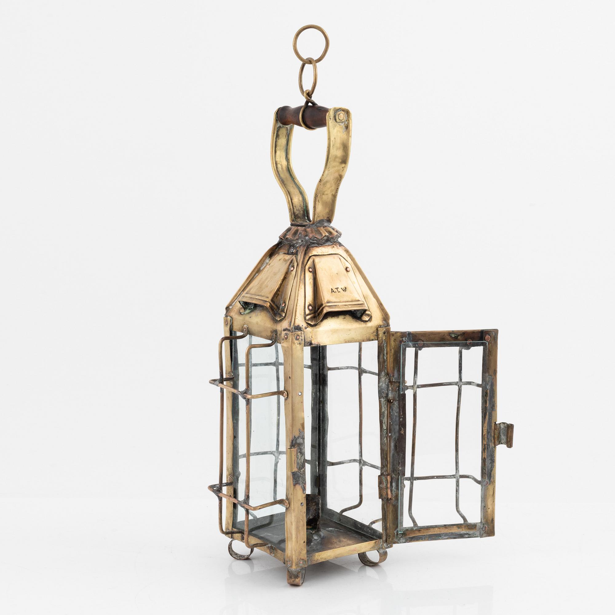 A metal storm lantern, marked A.T, circa 1900.