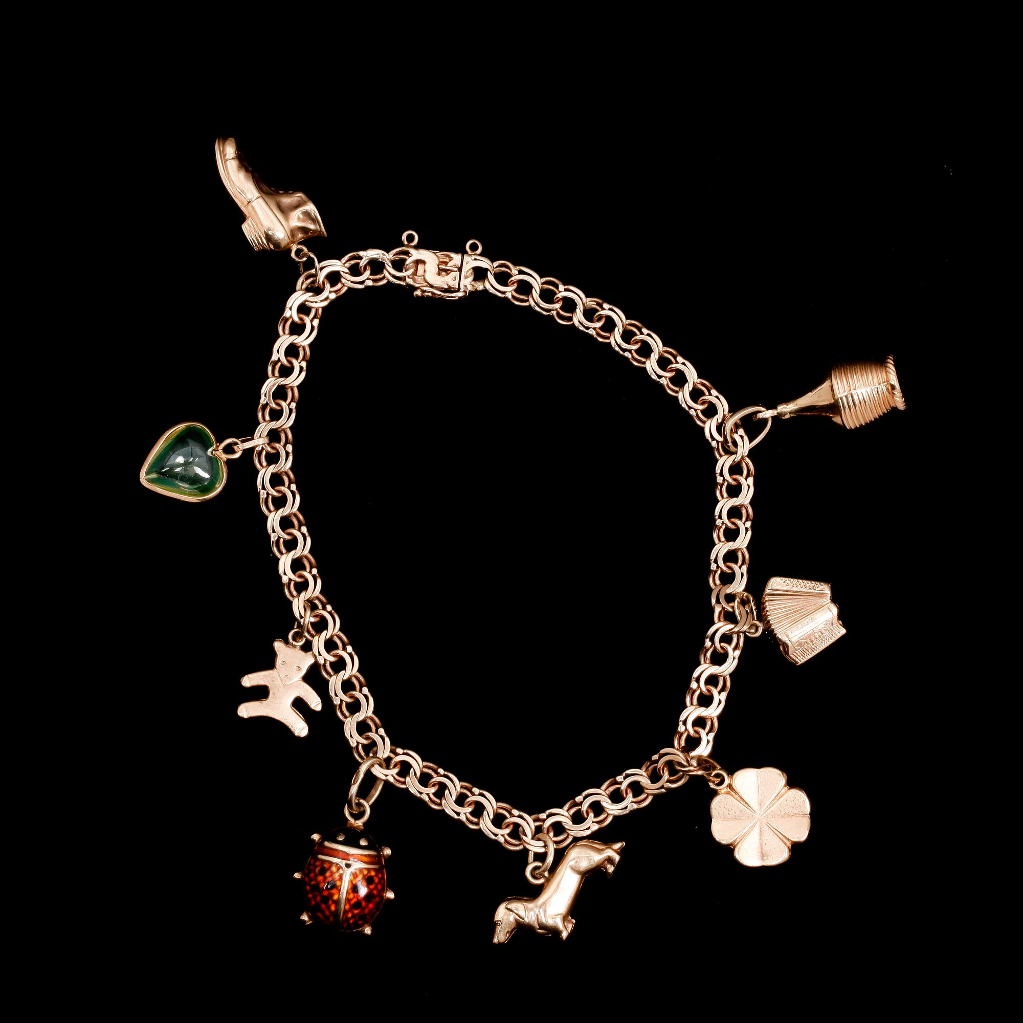 ARMBAND, guld 18k, med berlocker. Sverige, 1949. Vikt ca 15 g.