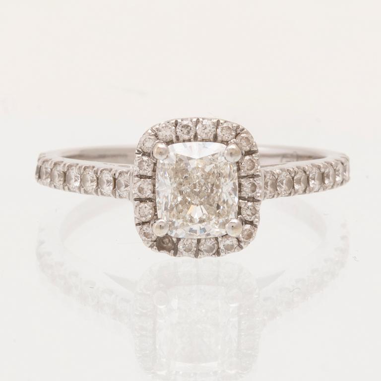 An 18K white gold ring set with a modified cushion-cut diamond and round brilliant-cut diamonds.