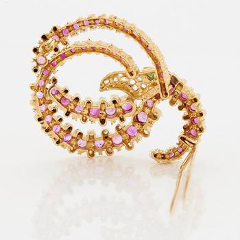 An Ilias Lalaounis brooch in 18K gold set with faceted rubies, an emerald and rose-cut diamonds.