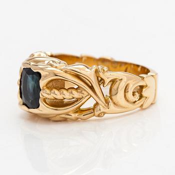 An 18K gold ring with a sapphire.