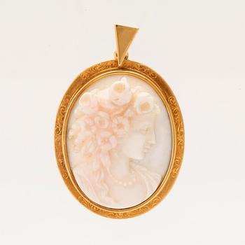 A pendant set with a shell cameo and 18K gold.