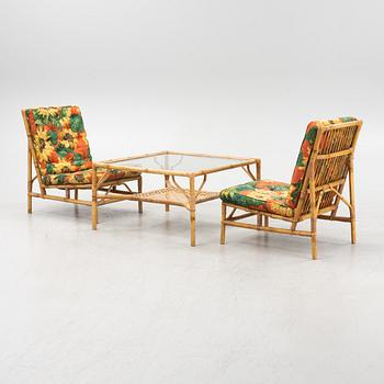 A pair of wicker lounge chairs and a table, 1950's.