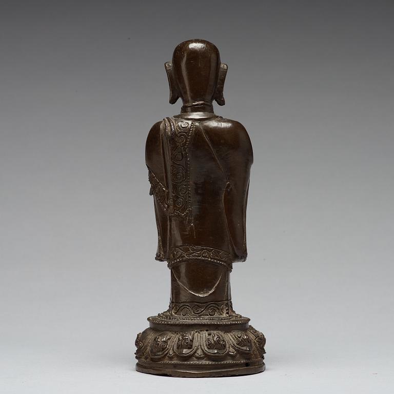 A bronze figure of a standing buddha, late Ming dynasty (1368-1644).