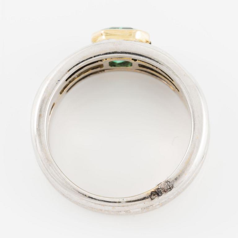 A ring in 18K gold set with a faceted emerald and baguette-cut diamonds.