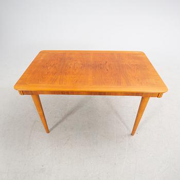 A 1940s mahogany and walnut dining table.