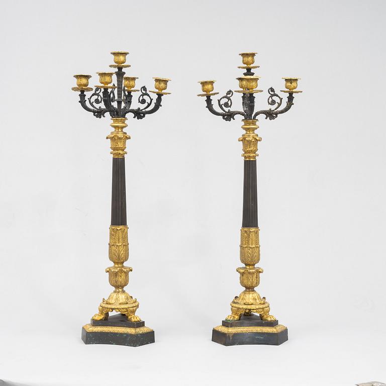 A pair of French Empire-style patinated and gilt bronze five-light candelabra, later part 19th century.