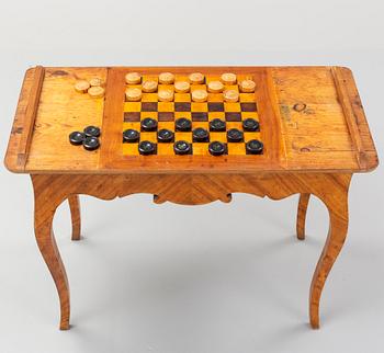 An elm veneered Rococo games table, 18th Century.