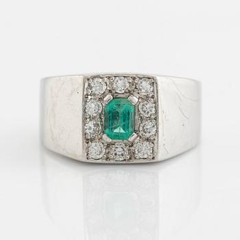 An 18K white gold ring set with a step-cut emerald and round brilliant-cut diamonds.