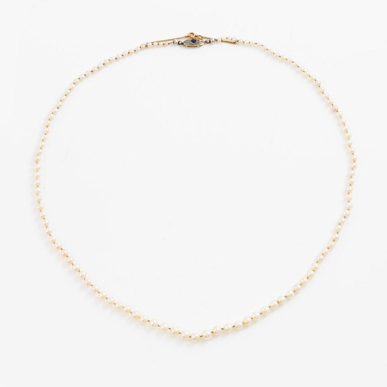Necklace of cultured pearls with a clasp in 18K gold set with a blue stone.