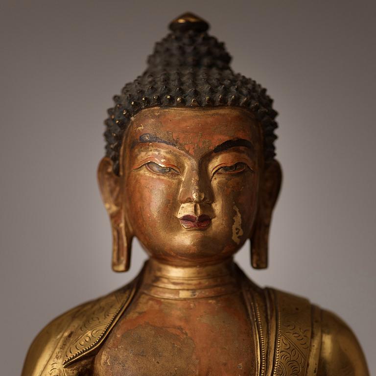 A finely cast Tibeto-Chinese gilt bronze figure of Shakyamuni Buddha, Qing dynasty, circa 1800.