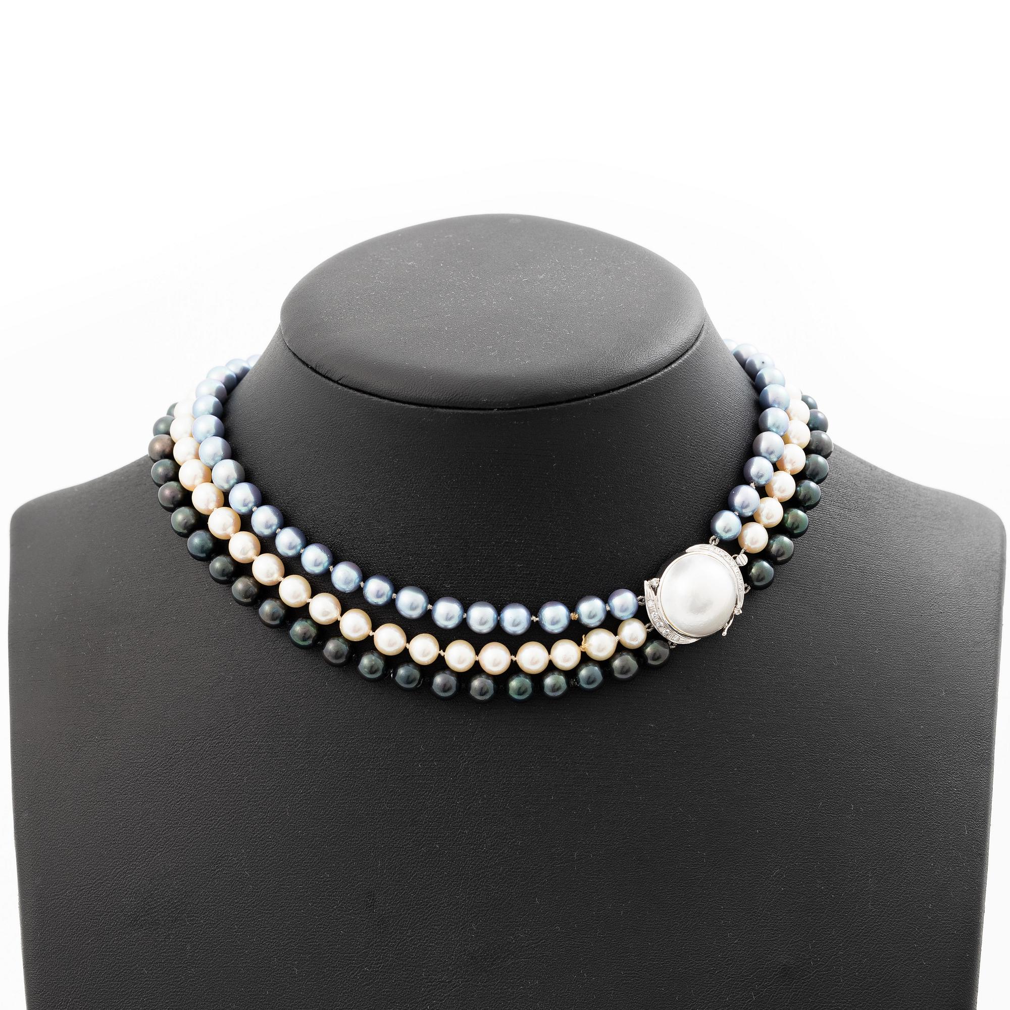 Three-row pearl necklace with cultured pearls, with an 18K white gold clasp set with a mabé pearl and octagonal-cut diamonds.