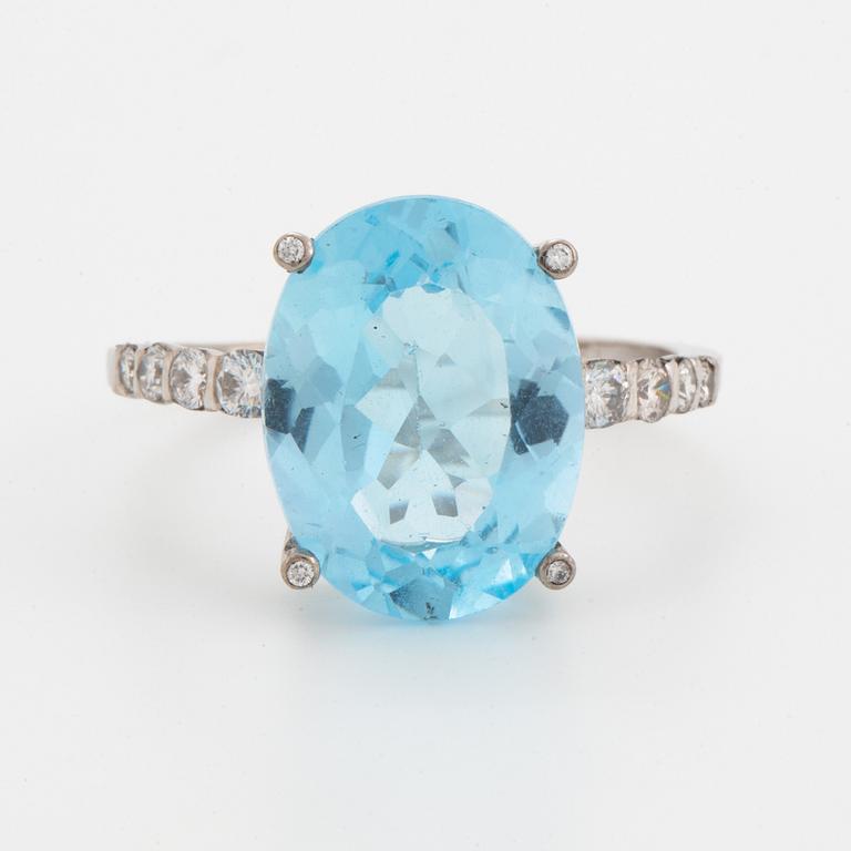 Oval faceted blue topaz and brilliant-cut diamond cocktail ring.