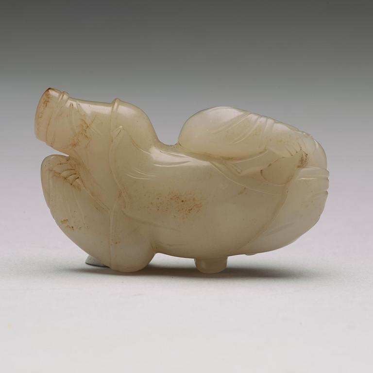 A nephrite figure of a reclining boy holding a lingzhi fungus, 20th Century.