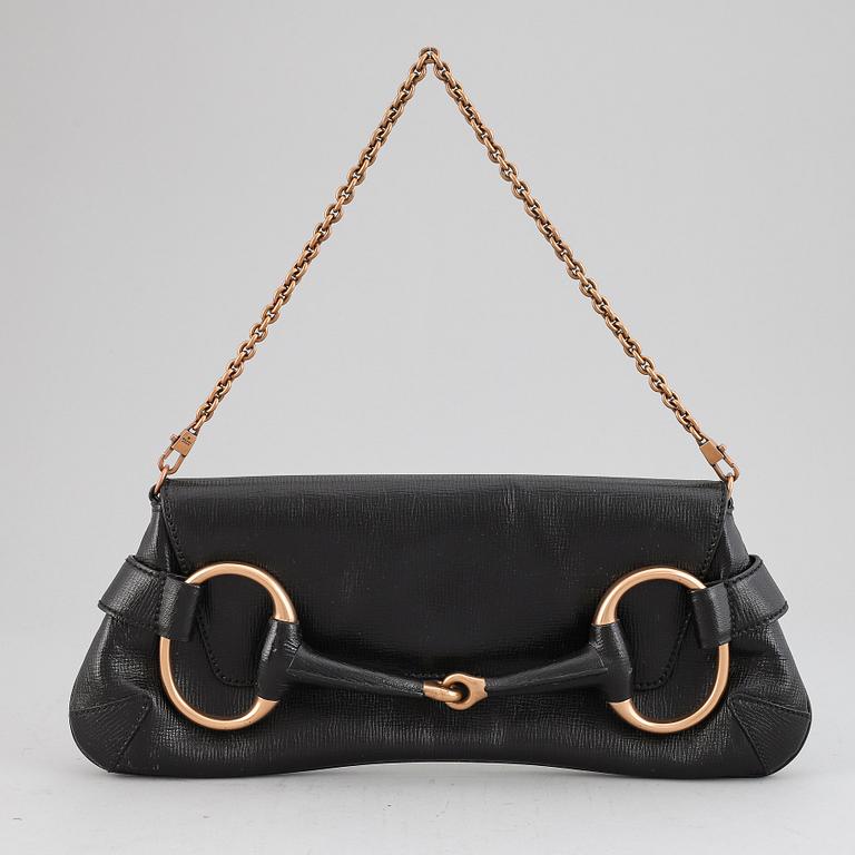 GUCCI, a black leather handbag.