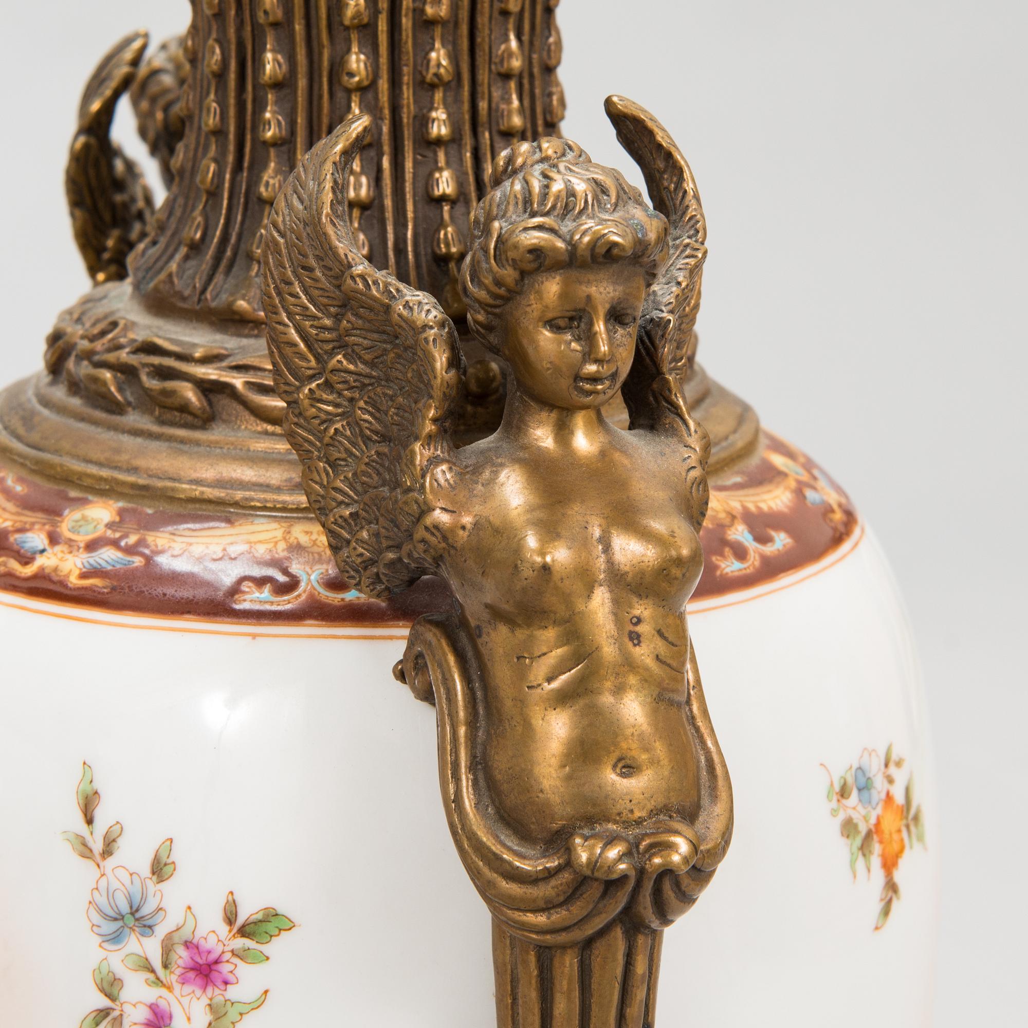 A pair of urns with lids, in bronze and porcelain, 20th century.