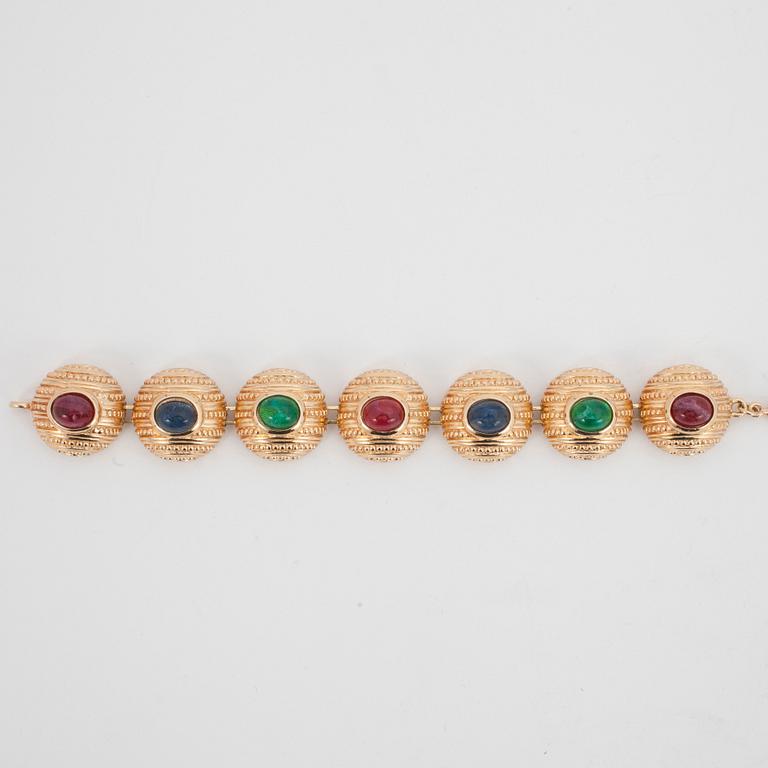 CHRISTIAN DIOR, a gold colored metall braclet with decorative glass stones.