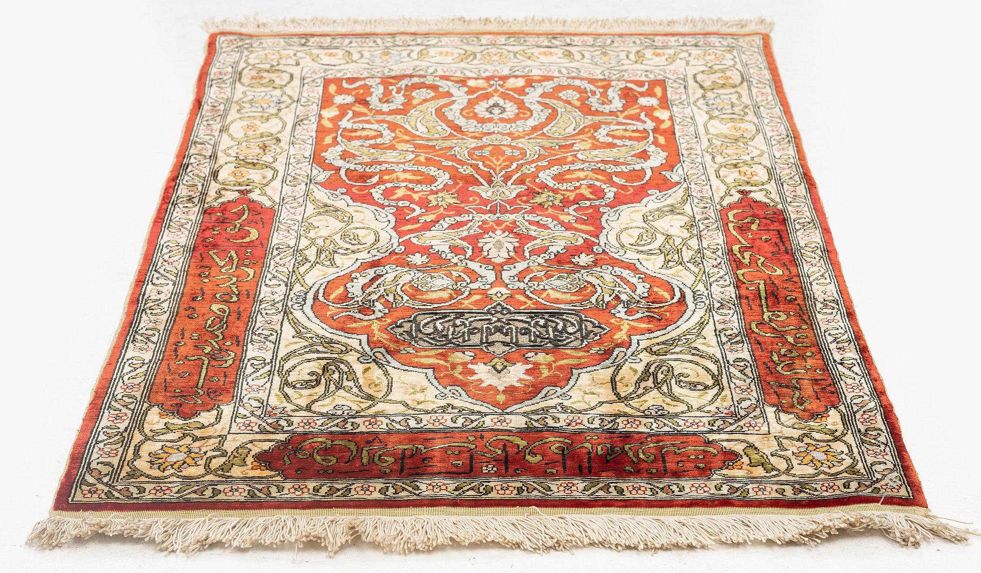 A silk and metal Hereke rug, c. 86 x 52 cm.