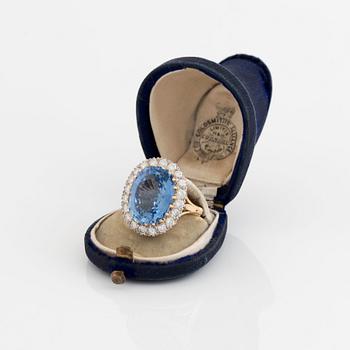 Ring 18K guld med en fasettslipad safir och runda briljantslipade diamanter.