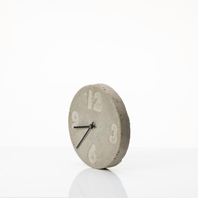 Stina Lindholm, a contemporary concrete planter 'Spira', a concrete flower pot and a wall clock.