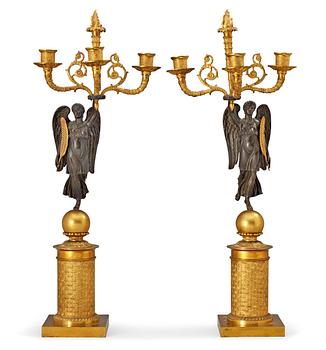 598. A pair of French Empire early 19th century gilt and patinated bronze three-light candelabra.