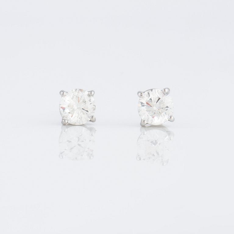 A pair of brilliant cut diamond earrings.