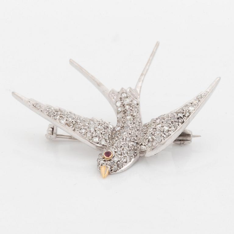 A platinum and gold brooch set with rose-cut dimonds and a ruby, in the form of a bird.