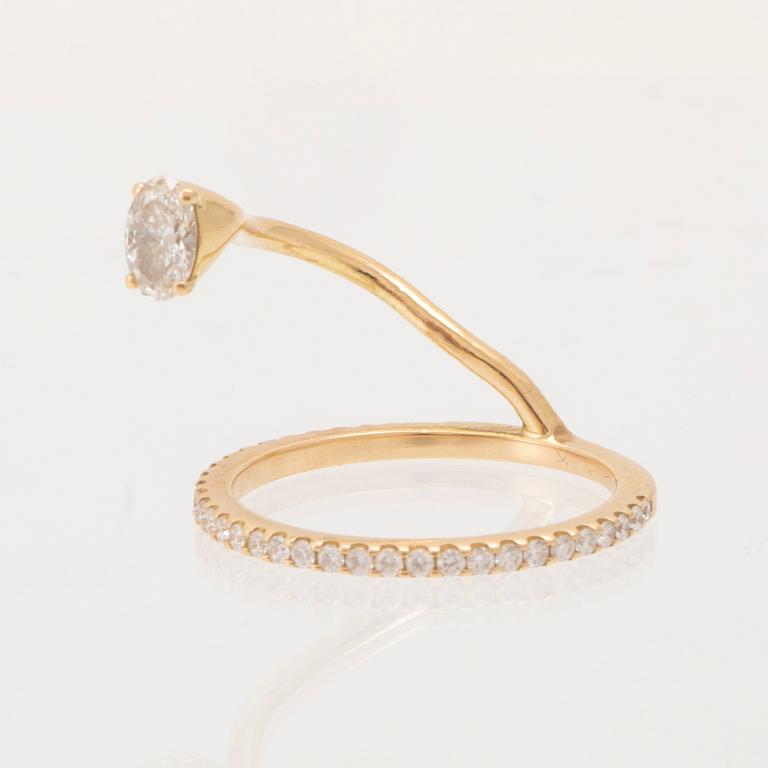 An 18K gold ring set with an oval cut and round brilliant cut diamonds by LWL Jewelry.