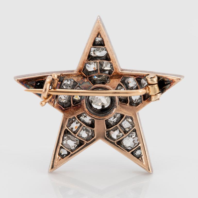 A 14K gold and silver star brooch set with old-cut diamonds.