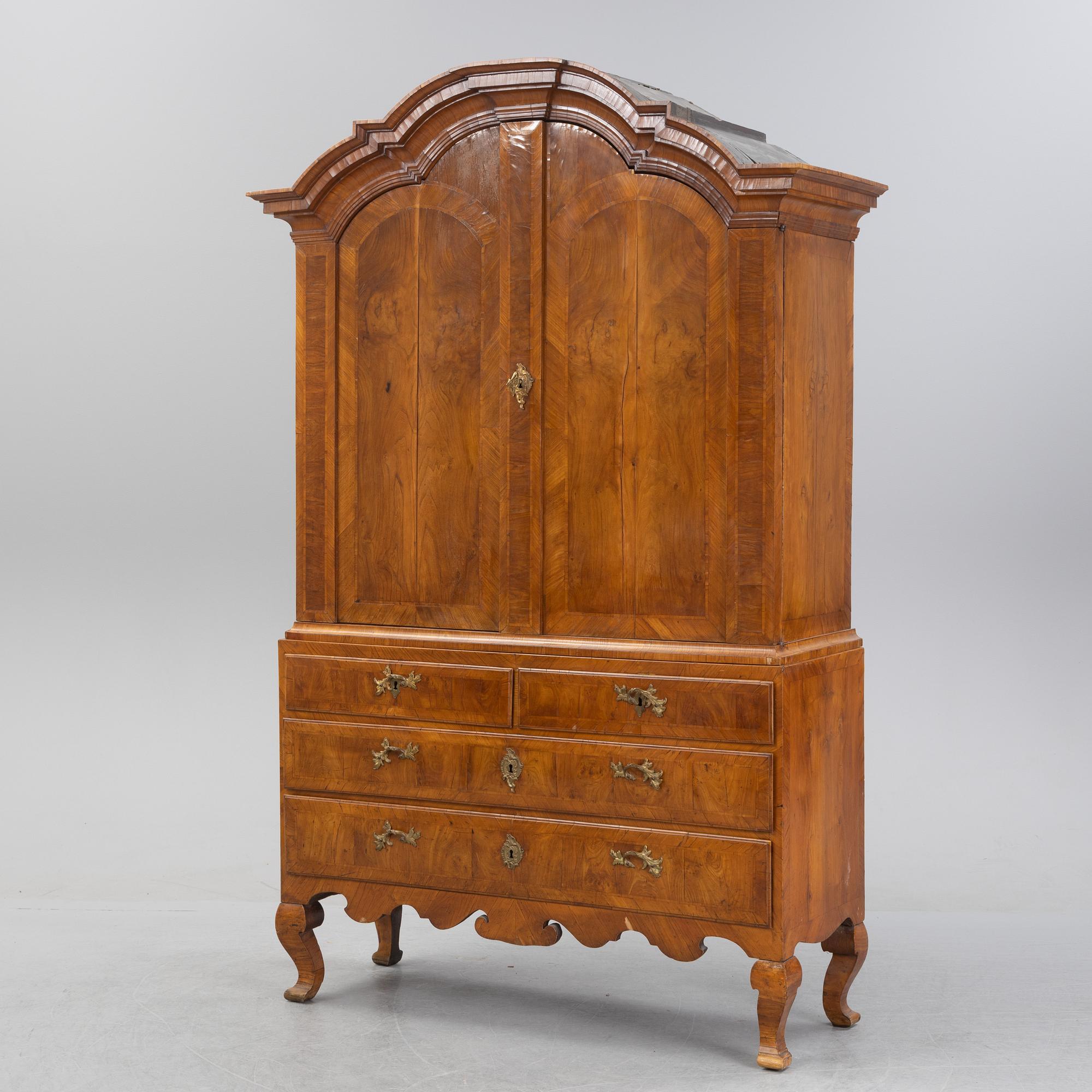 A walnut-veneered rococo cabinet in the manner of C. Linning, later part of the 18th Century.