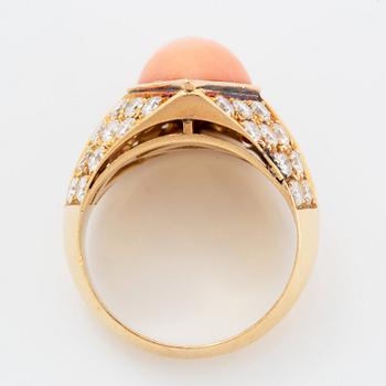 An 18K gold and coral ring set with round brilliant-cut diamonds.
