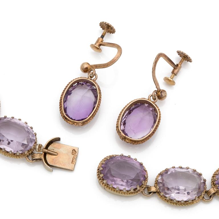 A gilded silver necklace and a pair of earrings set with faceted amethysts.