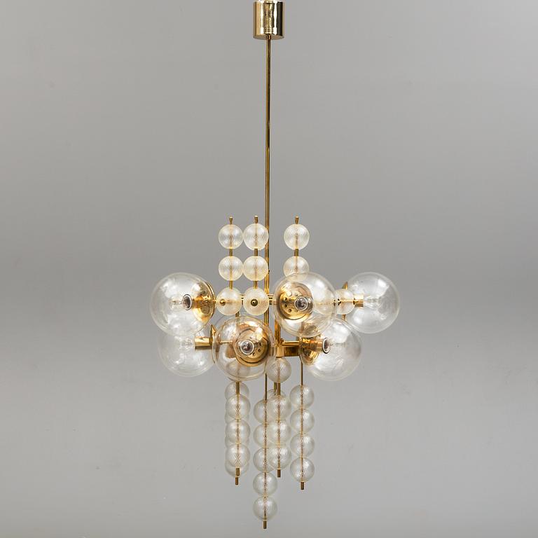 A 1970s brass ceiling light with glass shade. Height ca 144.