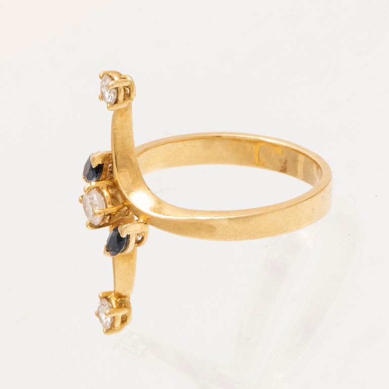 An 18K gold ring with marquise cut sapphires and round brilliant cut diamonds.