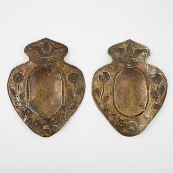 A pair of Baroque repoussé brass one-light sconces, first part of the 18th Century.