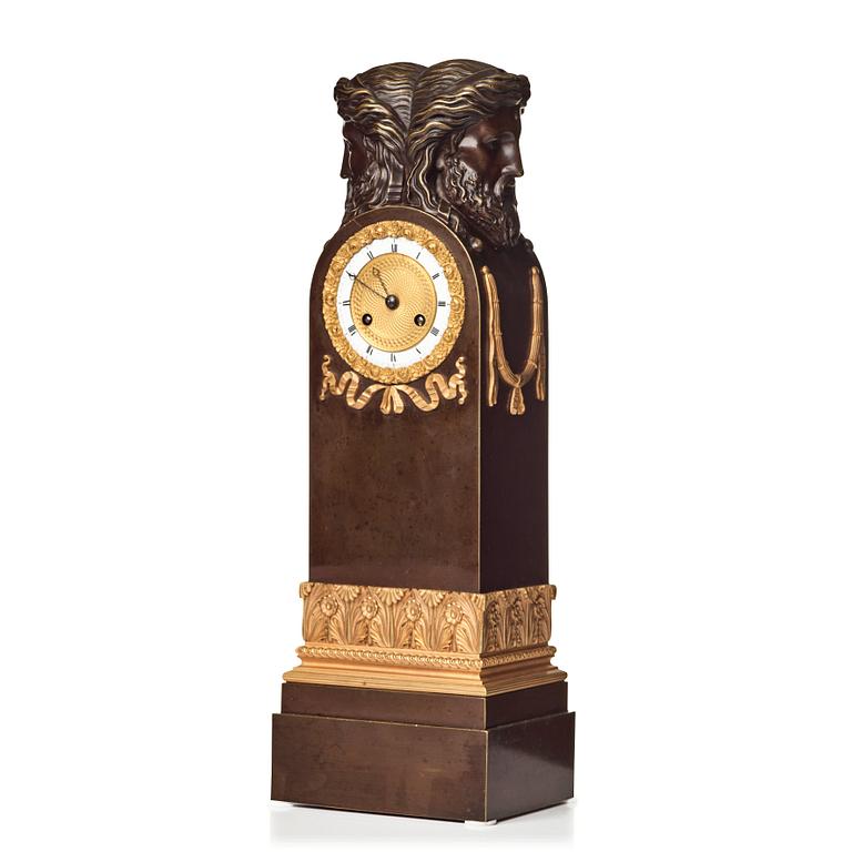 An Empire early 19th century gilt and patinated bronze mantel clock.