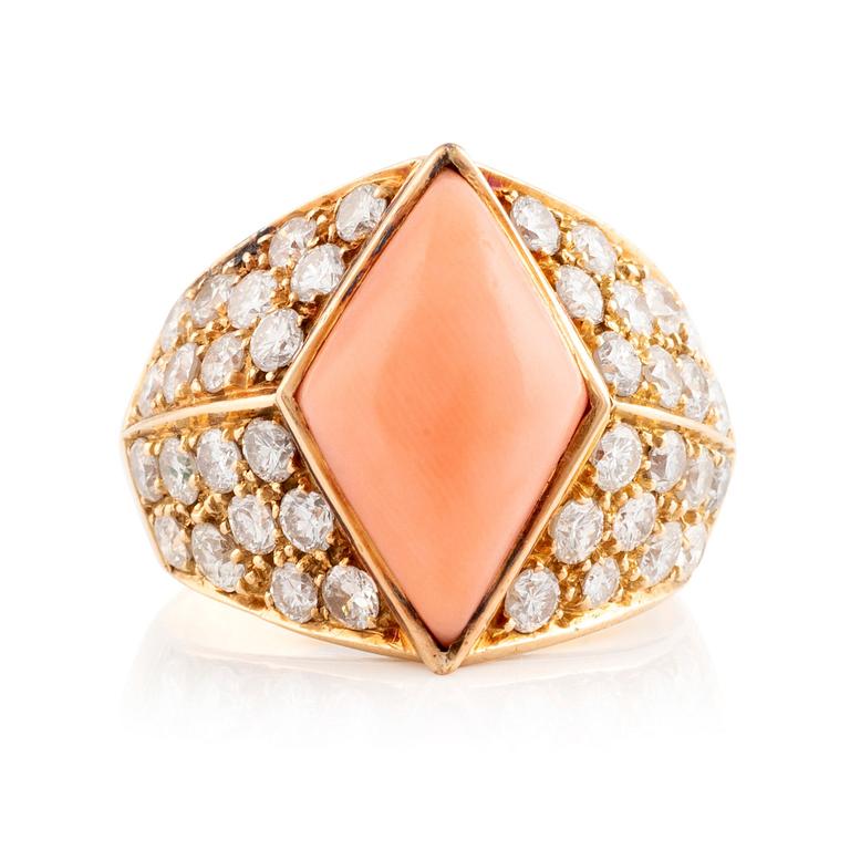 An 18K gold and coral ring set with round brilliant-cut diamonds.