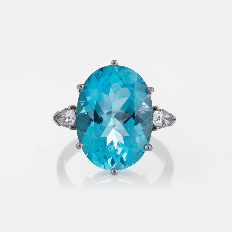 An 18K white gold ring set with a faceted topaz and two pear shaped brilliant-cut diamonds.