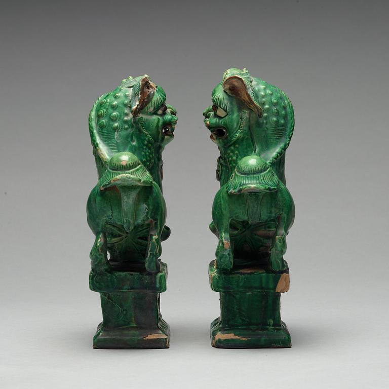 A pair of green glazed buddhist lions, Ming dynasty (1368-1644).