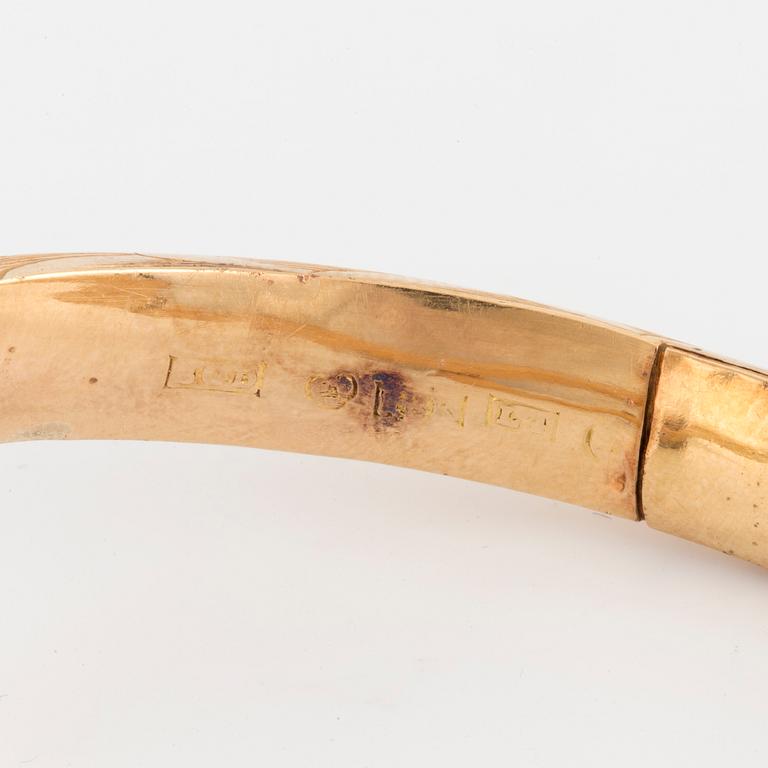 An 18K gold snake bangle with rose-cut diamonds.