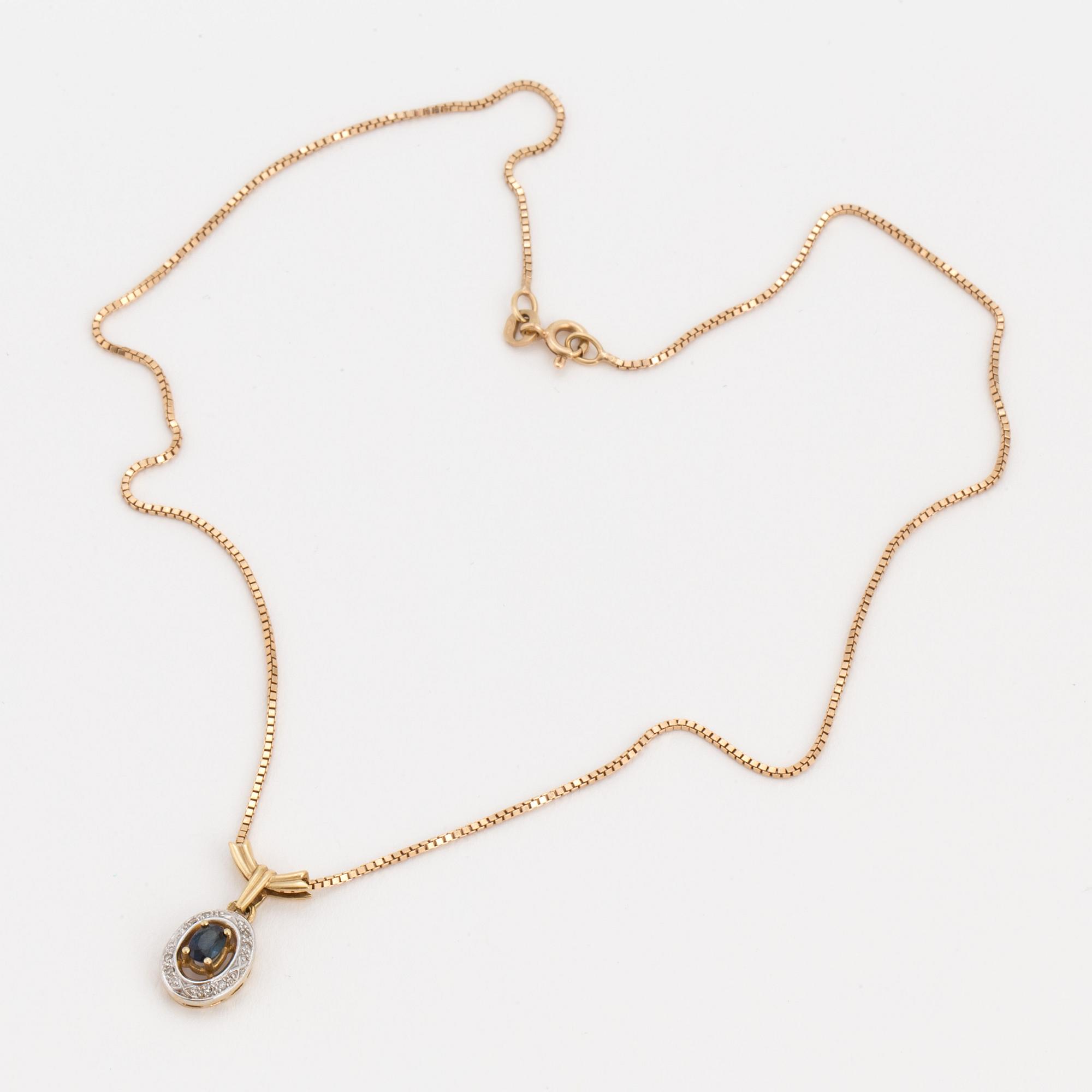 An 18K gold chain and pendant set with an oval, mixed-cut, synthetic sapphire surrounded by eight-cut diamonds.