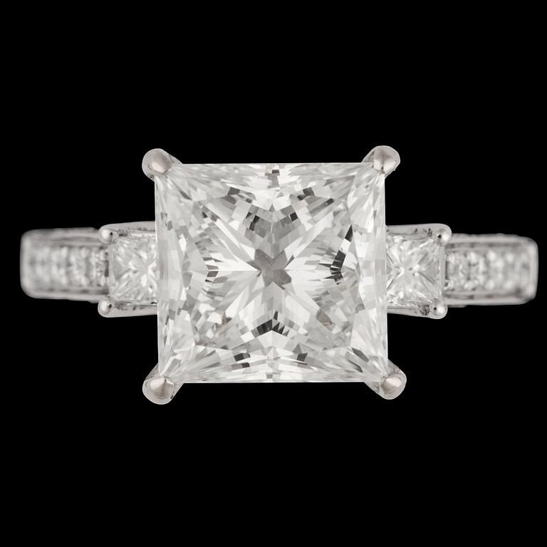 A princess cut diamond ring, 4.03 cts. and smaller brilliant cut diamonds.