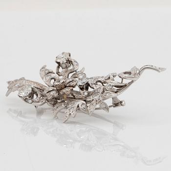 An 18K white gold brooch set with round brilliant-cut diamonds.