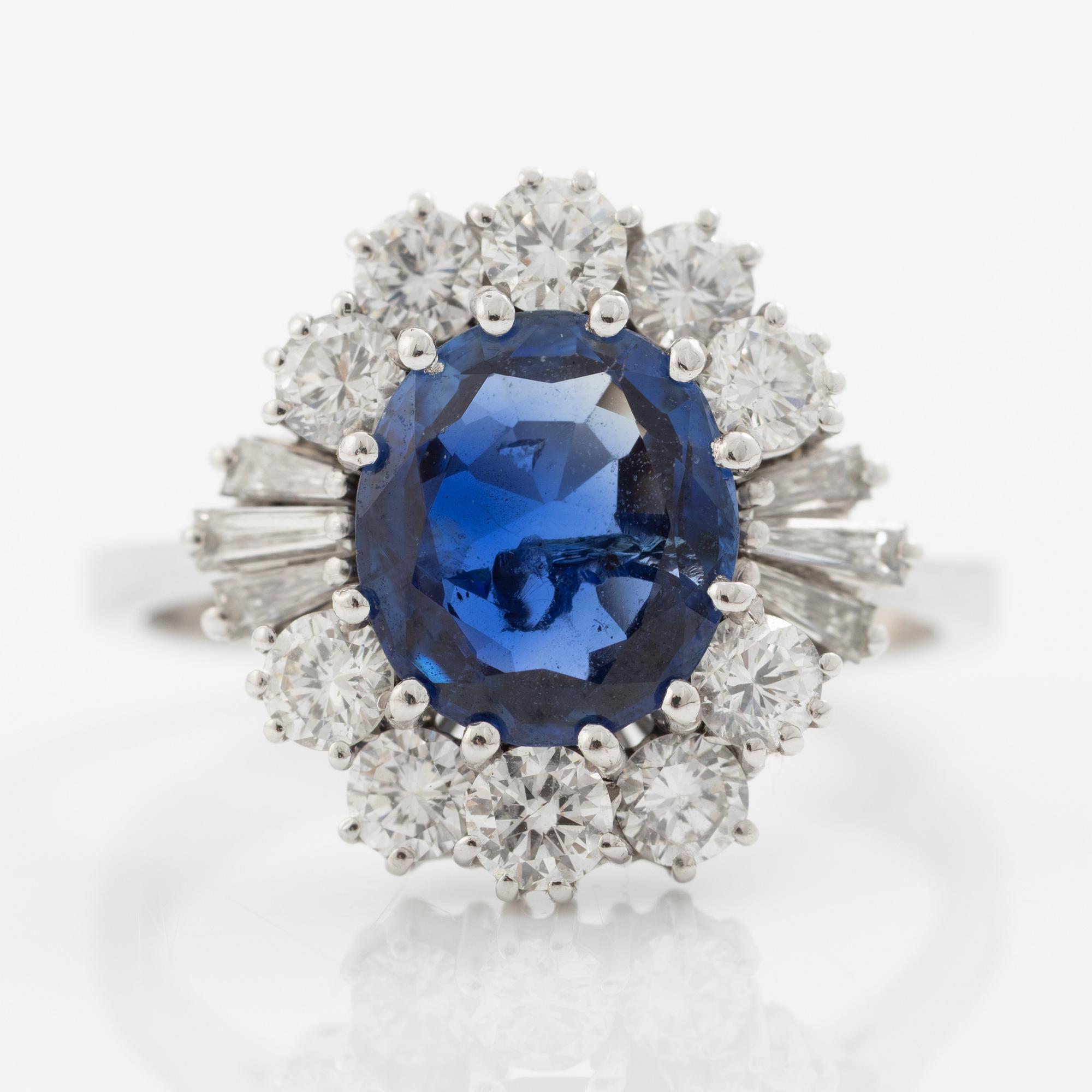 Ring in 18K white gold set with a faceted sapphire and round brilliant-cut and modified baguette-cut diamonds.