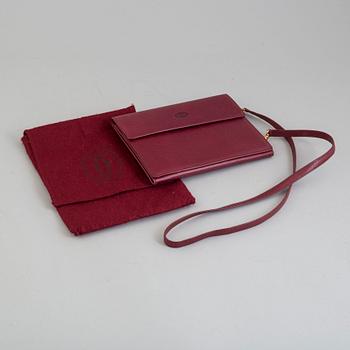 A burgundy leather bag from les must de Cartier.