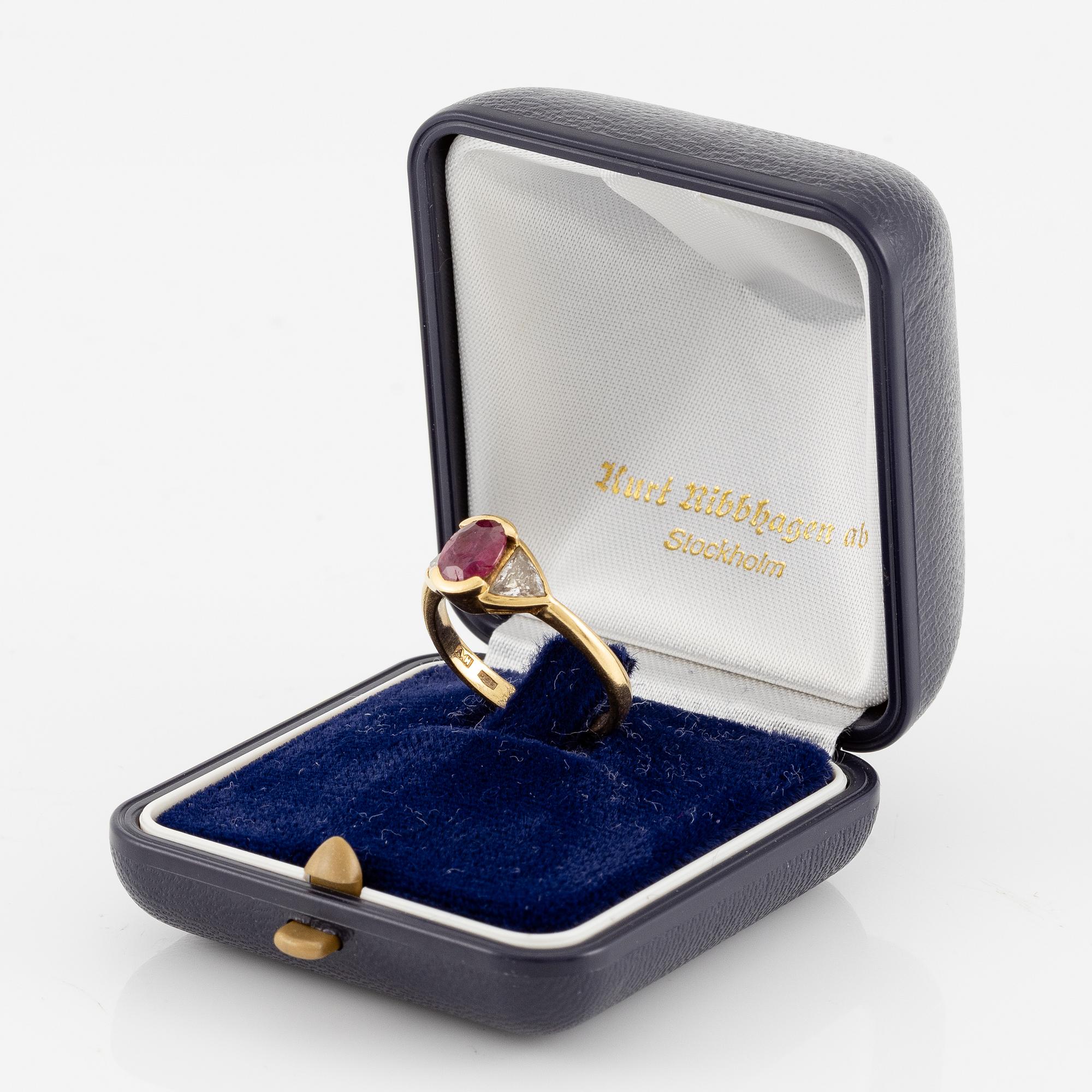 Ring 18K guld med en fasettslipad rubin samt två triangelformade briljantslipade diamanter.